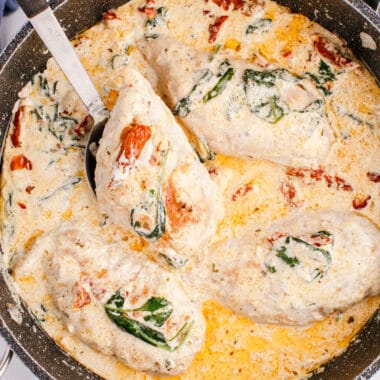 square image of tuscan chicken in a skillet with one chicken breast on a spoon
