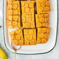 upside down banana cake cut into slices on a platter with a cake serve with recipe name at the bottom