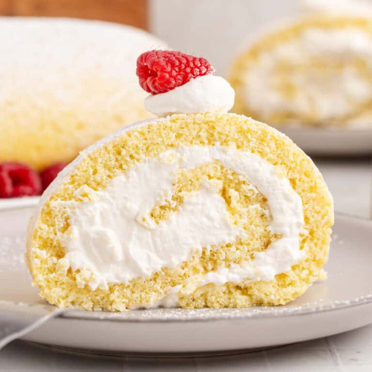 square image of a slice of vanilla swiss roll on a plate