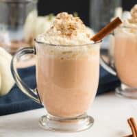 square image of pumpkin spice cocktail served in a mug with whipped cream and cinnamon