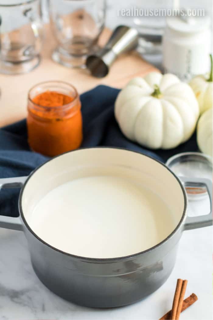 ingredients for warm pumpkin spice cocktail with a large pot