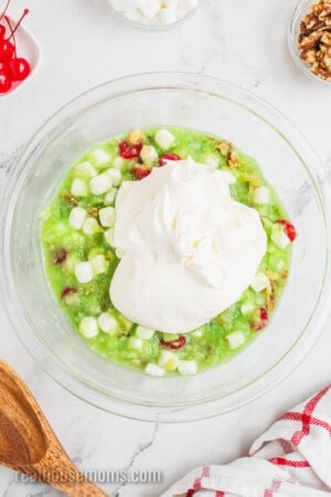 cool whip added to a mixing bowl with watergate salad base