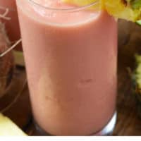 Large glass of watermelon colada with pineapple garnish