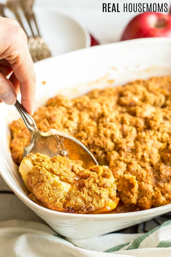 Serving spoon lifting Weight Watchers Apple Cobbler for the baking dish for serving
