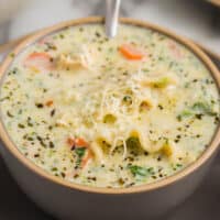 square image of a bowl of white chicken lasagna soup with a spoon