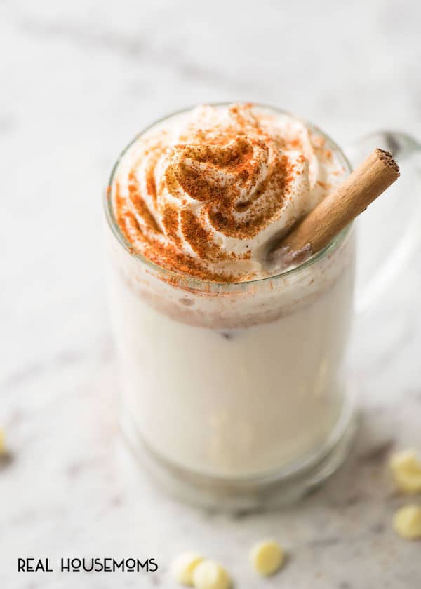 A mug of White Mexican Hot Chocolate garnished with a cinnamon stick