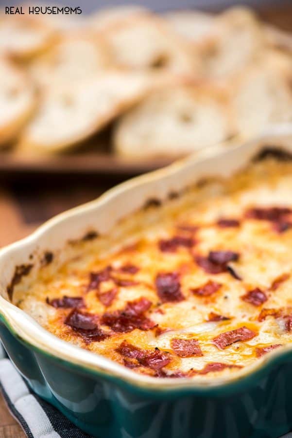baked dip with white pizza flavors just out of the oven, served with baguette slices