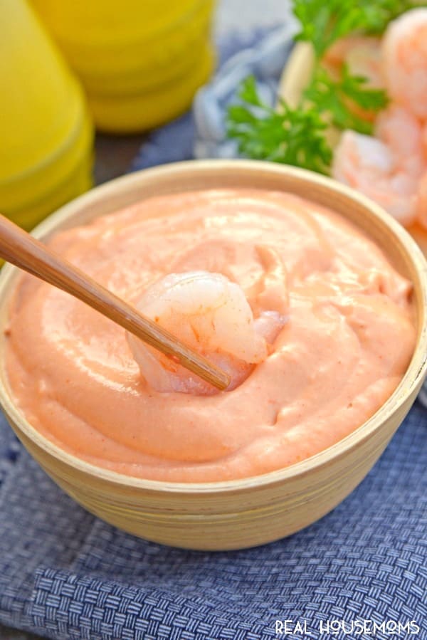 Chop sticks dipping shrimp into a bowl of Yum Yum Sauce
