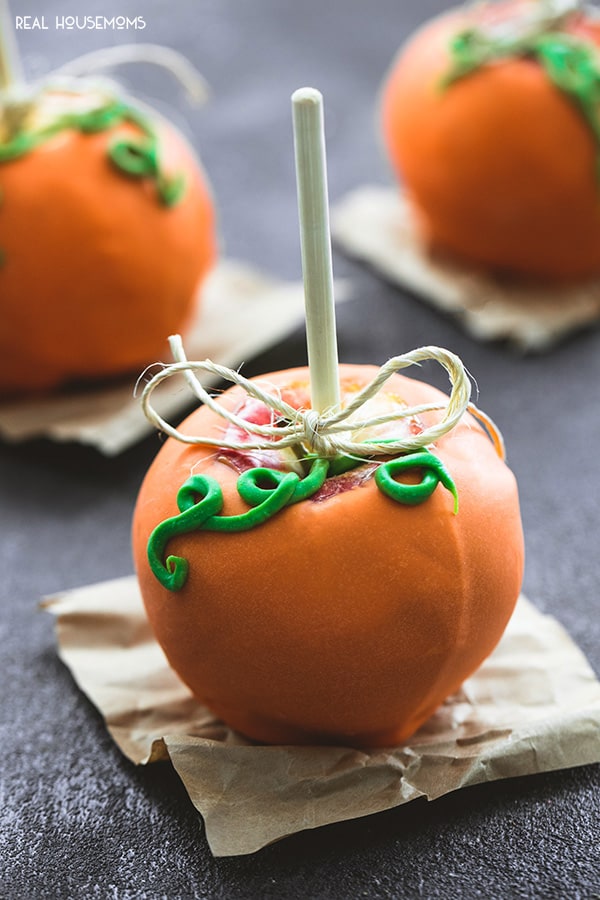 Caramel Apple Pumpkins topped with a green candy swirl stem and a just string bow on top