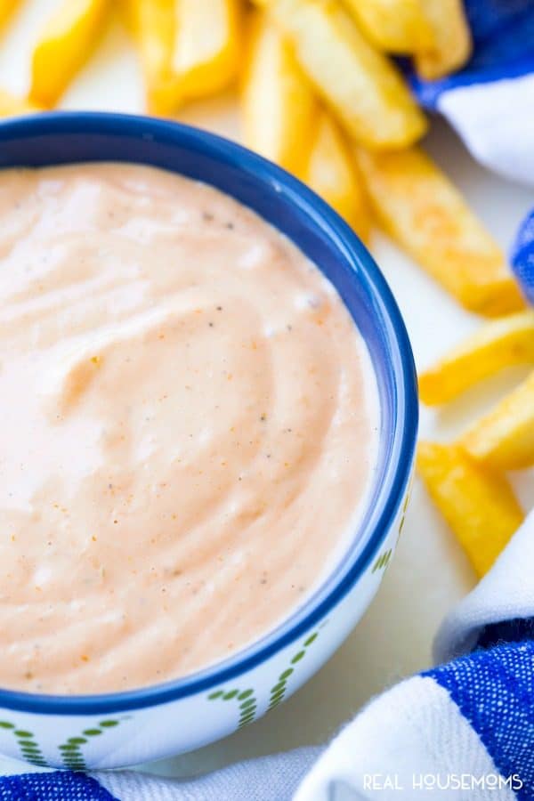 Close up of fry sauce with a a carton of french fries along side for dipping