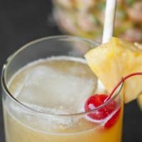 HAWAIIAN STONE SOUR Cocktail in einer Klasse mit Kirsche und Ananas garniert.