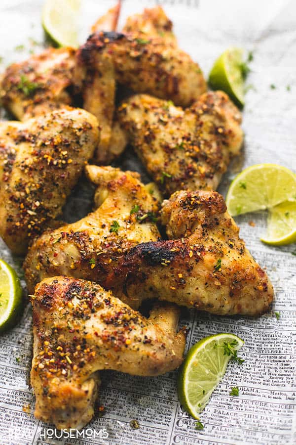 Close up of baked Jerk Chicken Wings with delicious jerk seasoning and lime wedges alongside
