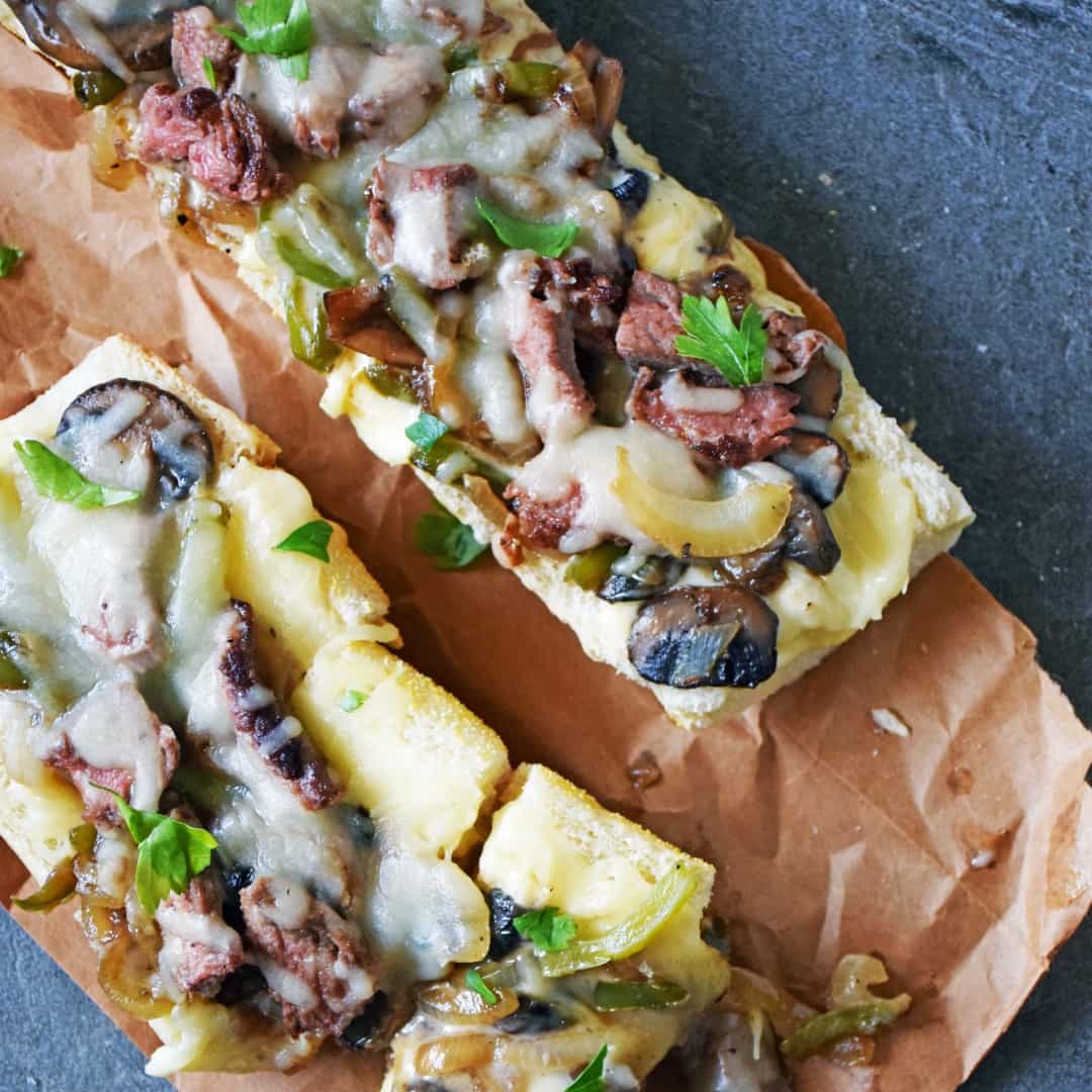 PHILLY CHEESE STEAK BREAD is an easy appetizer, dinner, or lunch recipe inspired by the traditional sandwich. This beefy, cheesy pizza bread disappears quickly, and is a snap to make!
